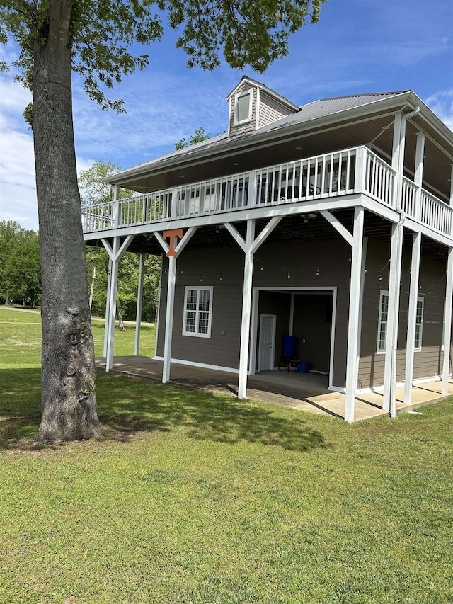 rear view of property featuring a lawn, a deck, and a patio area
