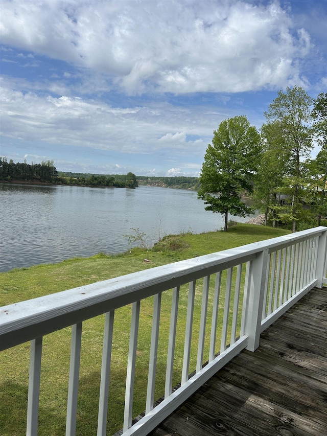 wooden terrace with a yard and a water view