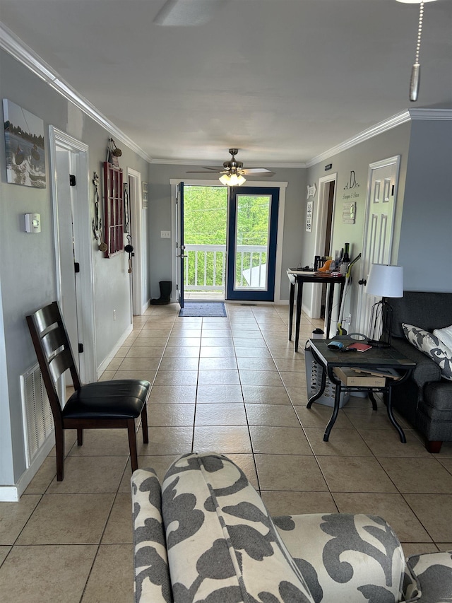 living room featuring light tile patterned floors, visible vents, ceiling fan, baseboards, and ornamental molding