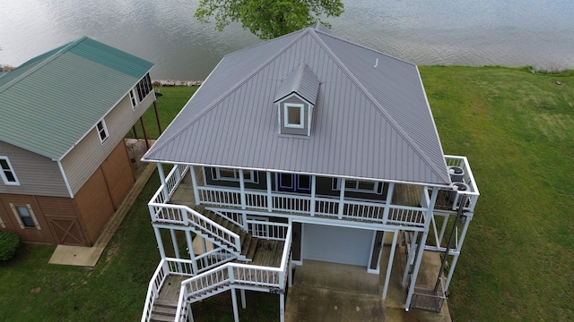 rear view of property featuring a lawn, metal roof, and stairs
