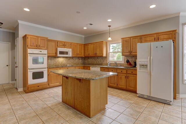 kitchen with light stone countertops, light tile patterned flooring, a kitchen island, backsplash, and white appliances