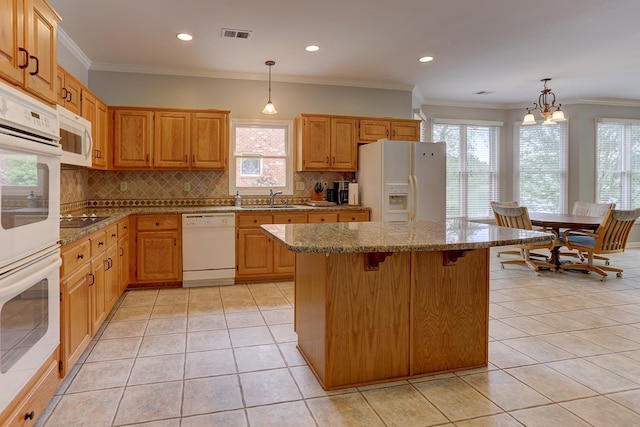 kitchen featuring a wealth of natural light, decorative backsplash, and white appliances