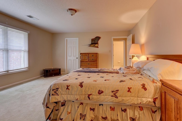 bedroom with baseboards, visible vents, and light carpet
