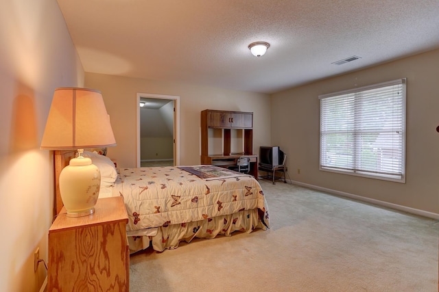 bedroom with a textured ceiling, visible vents, carpet flooring, and baseboards