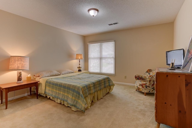 bedroom featuring a textured ceiling, visible vents, light carpet, and baseboards