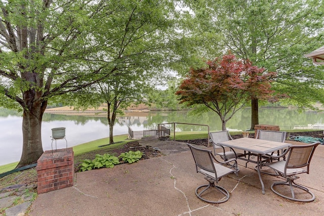 view of patio with a water view and outdoor dining area