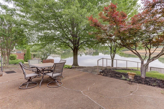 view of patio / terrace featuring a water view and fence