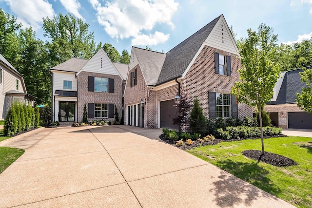 515 Saunders Creek Cir, Rossville, TN 38066 - view of front facade featuring driveway, roof with shingles, brick siding, a front lawn, and a garage