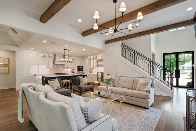 515 Saunders Creek Cir, Rossville, TN 38066 - living area featuring baseboards, stairway, a chandelier, beam ceiling, and visible vents