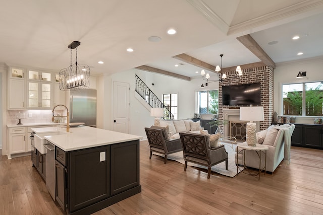 515 Saunders Creek Cir, Rossville, TN 38066 - living room with beamed ceiling, recessed lighting, an inviting chandelier, stairway, and light wood-style flooring