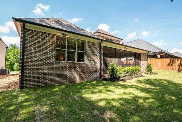 515 Saunders Creek Cir, Rossville, TN 38066 - back of house featuring a yard, brick siding, fence, a sunroom, and cooling unit