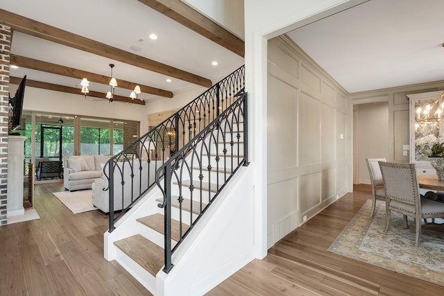 515 Saunders Creek Cir, Rossville, TN 38066 - staircase with a decorative wall, visible vents, beam ceiling, wood finished floors, and a notable chandelier
