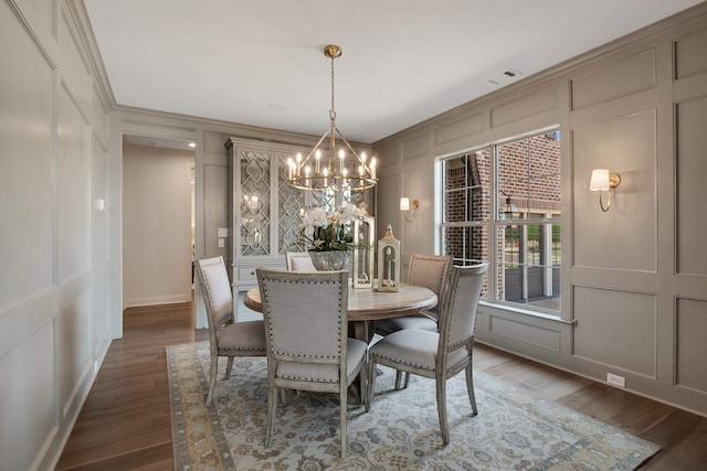 515 Saunders Creek Cir, Rossville, TN 38066 - dining space with wood finished floors, a decorative wall, crown molding, and a chandelier