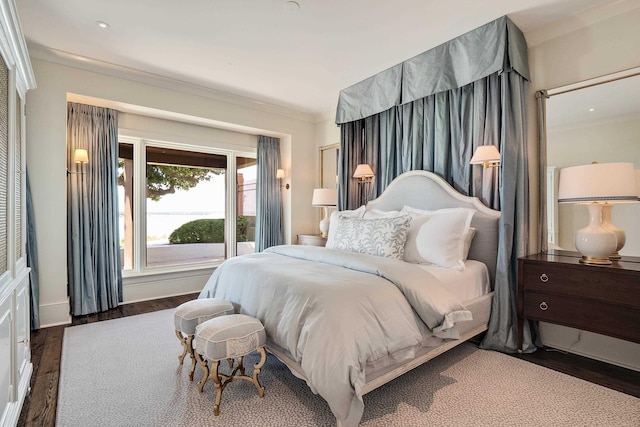 bedroom with ornamental molding and wood finished floors