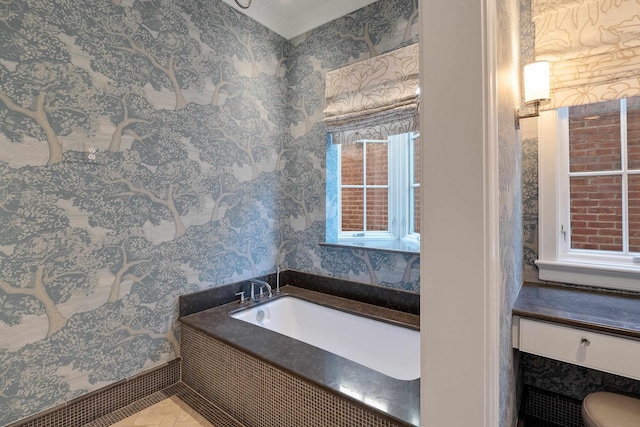 bathroom with wallpapered walls, toilet, and a garden tub