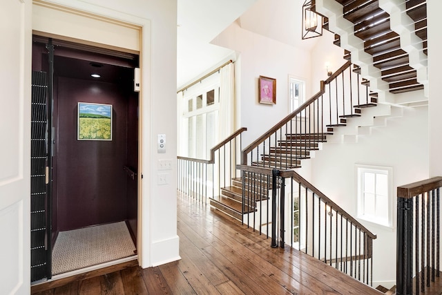 foyer with stairs, baseboards, elevator, and dark wood finished floors