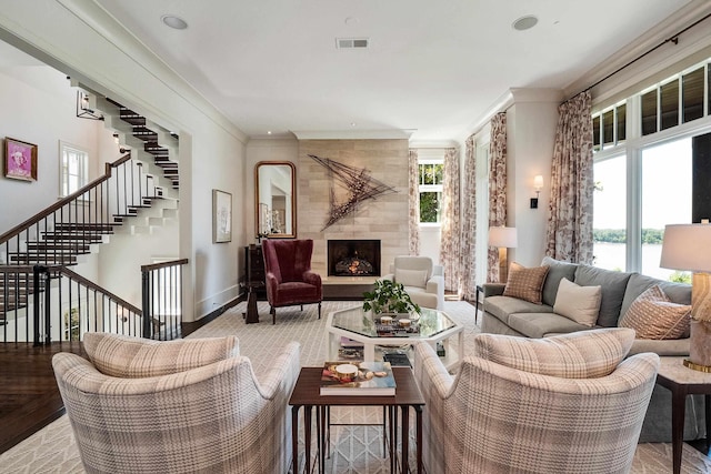 living room with crown molding, stairway, visible vents, a high end fireplace, and baseboards
