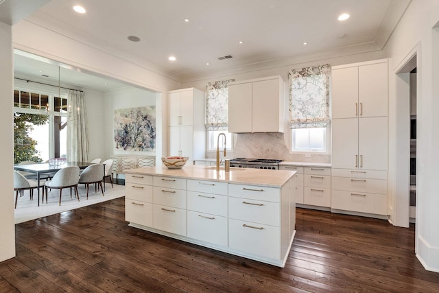 kitchen featuring visible vents, a healthy amount of sunlight, crown molding, and a sink