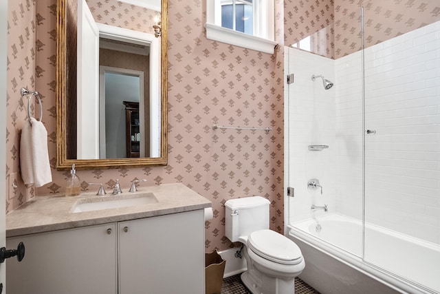 full bathroom featuring bath / shower combo with glass door, vanity, toilet, and wallpapered walls
