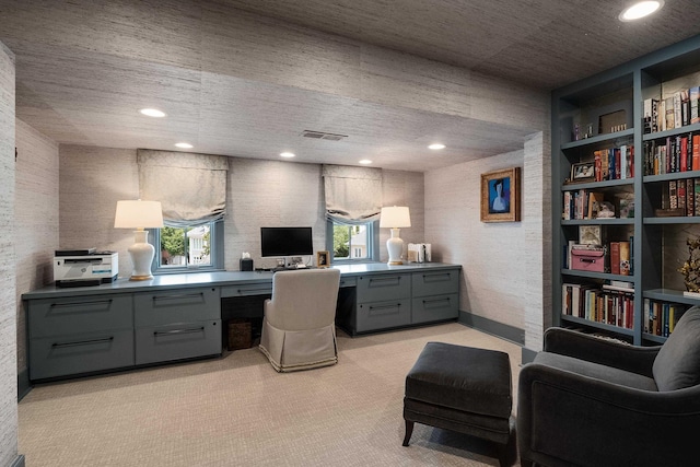 office space featuring visible vents, a healthy amount of sunlight, built in features, and light colored carpet