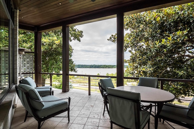 sunroom / solarium featuring a water view and wooden ceiling