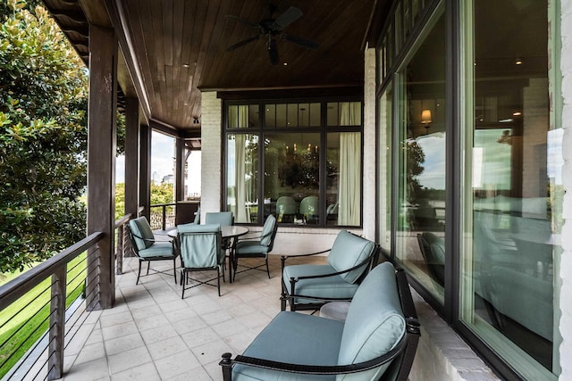 balcony with outdoor dining area and a ceiling fan