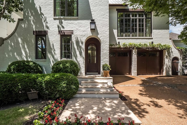 view of front of house with concrete driveway, stone siding, and a garage