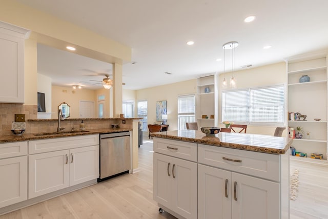 kitchen with a sink, decorative backsplash, open shelves, stainless steel dishwasher, and white cabinets