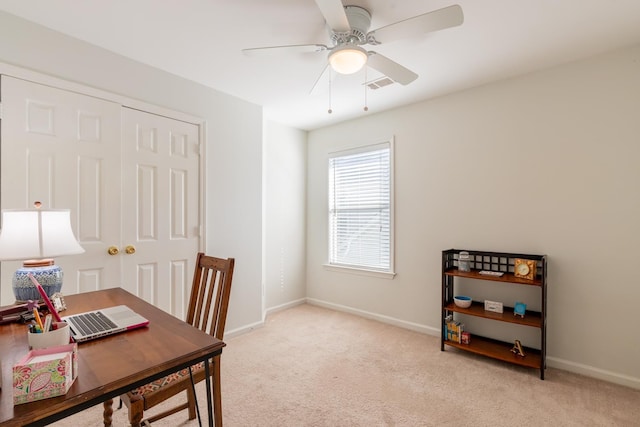 office space featuring visible vents, a ceiling fan, baseboards, and light carpet