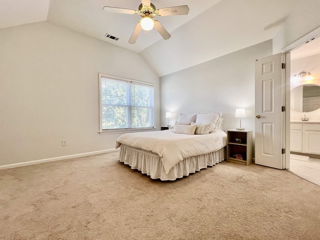 bedroom with vaulted ceiling, light carpet, ensuite bathroom, visible vents, and a ceiling fan