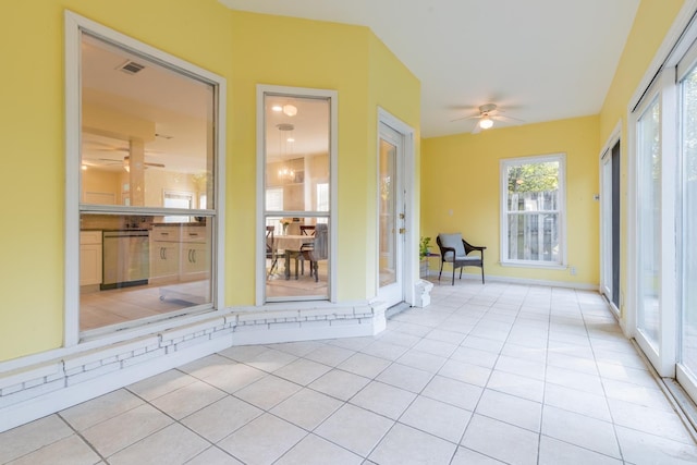 unfurnished sunroom with baseboards, visible vents, and tile patterned flooring