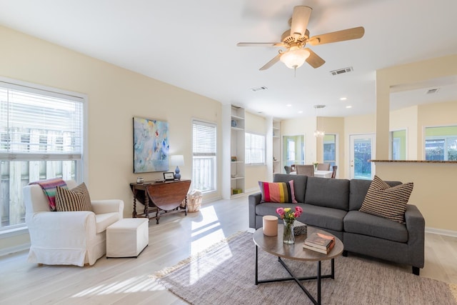 living room featuring a healthy amount of sunlight, visible vents, light wood-type flooring, and ceiling fan