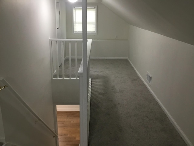 bonus room with baseboards, visible vents, carpet flooring, and vaulted ceiling