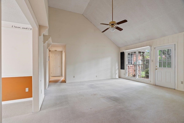 spare room featuring carpet, a ceiling fan, high vaulted ceiling, and baseboards