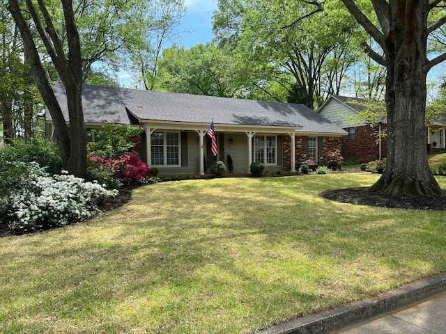 single story home featuring a shingled roof and a front yard