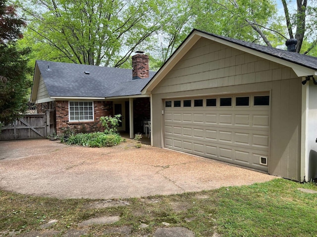 ranch-style home with a chimney, brick siding, a gate, a shingled roof, and an attached garage