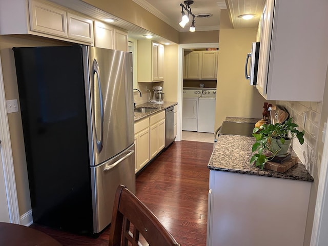 kitchen with decorative backsplash, a sink, separate washer and dryer, ornamental molding, and stainless steel appliances