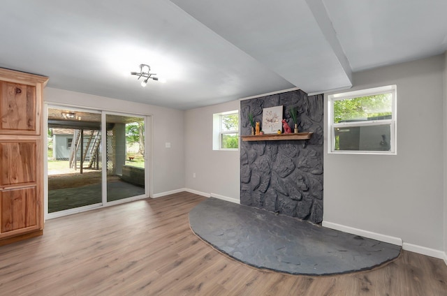 unfurnished living room with wood finished floors and baseboards