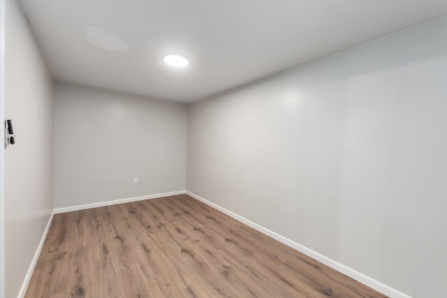 empty room featuring baseboards and light wood-type flooring