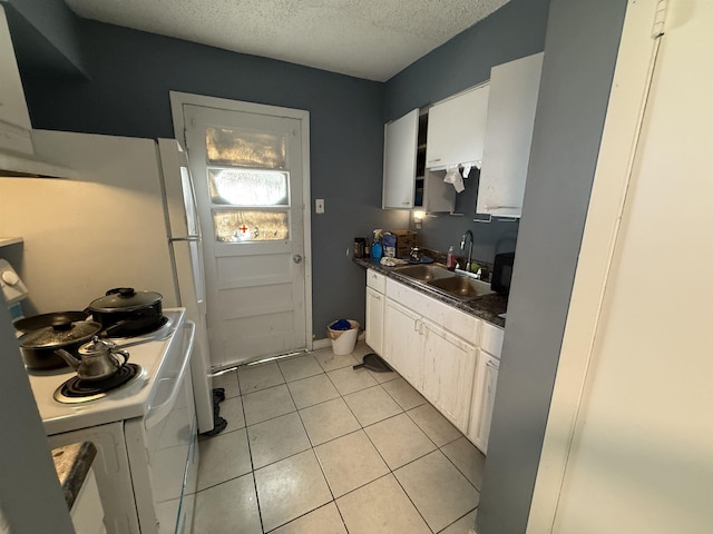 1040 Gordon St, Memphis, TN 38122 - kitchen with a sink, light tile patterned floors, white cabinetry, dark countertops, and a textured ceiling