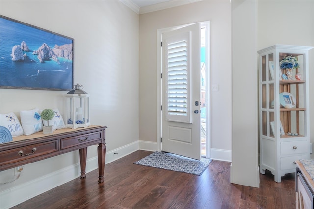 foyer with dark wood-style flooring, crown molding, and baseboards
