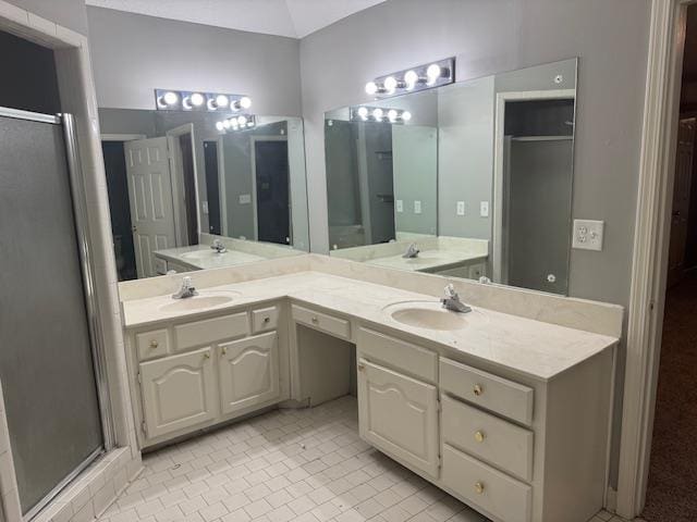 full bath featuring double vanity, a sink, and a shower stall