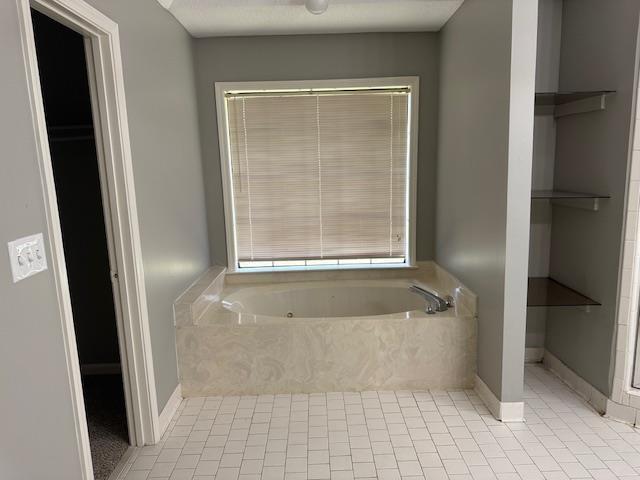full bath with a bath, tile patterned floors, and baseboards