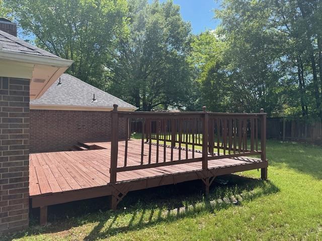 wooden deck with a yard and fence