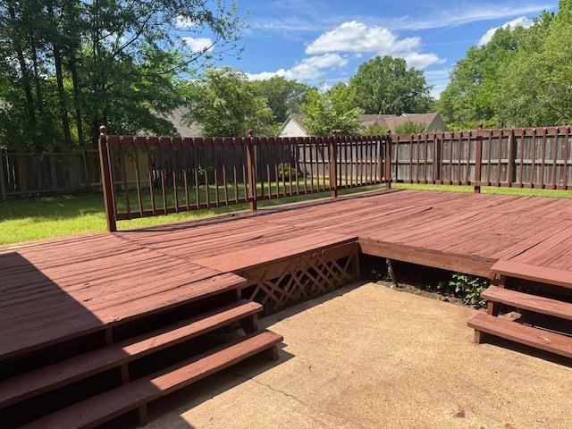 wooden deck with a fenced backyard