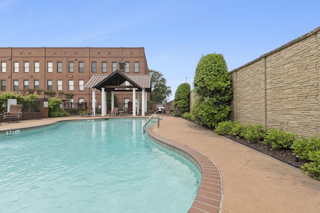 pool with a gazebo, a patio area, and fence
