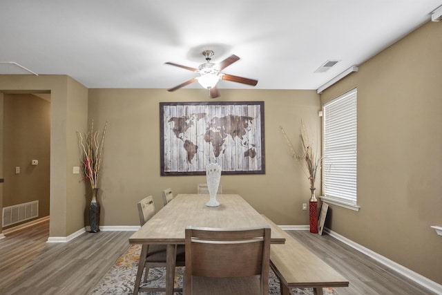 dining area featuring wood finished floors, visible vents, ceiling fan, and baseboards