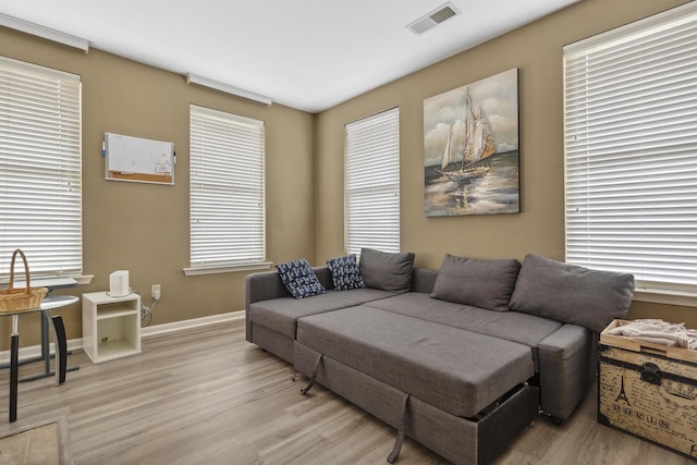 living area with visible vents, baseboards, a wealth of natural light, and light wood-style floors