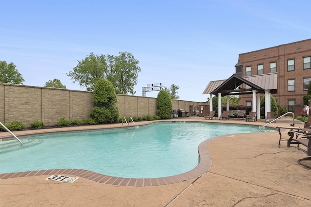 pool featuring a patio, a gazebo, and a fenced backyard