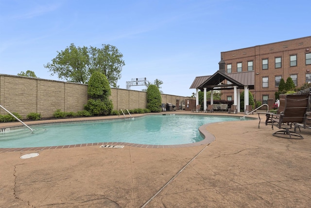 community pool featuring a gazebo, a fenced backyard, and a patio area